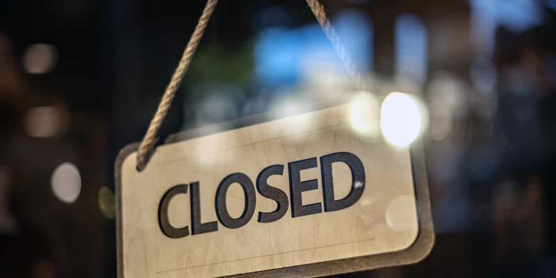 Closed sign on business door for LLC dissolution